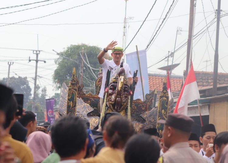 Menparekraf, Sandiaga Salahudin Uno, saat menaiki replika kereta kencana  yang diarak menuju Desa Astana, Kecamatan Gunungjati, Kabupaten Cirebon, yang masuk kategori 75 desa wisata terbaik di Indonesia, Minggu (6/8/2023)