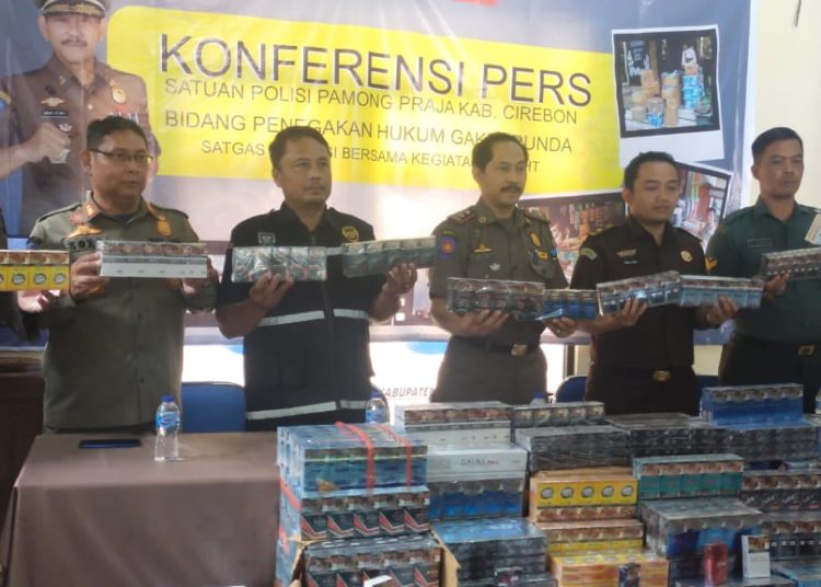 Tim Gabungan yang dikomandoi Satpol PP  saat menunjukan ribuan bungkus rokok ilegal hasil razia di wilayah Kabupaten Cirebon dalam konferensi pers, Senin (7/8/2023).