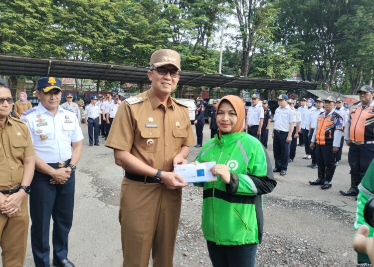 Pj Wali Kota H. Agus Mulyadi menyerahkan bantuan sosial kepada mitra ojek online di kantor Dinas Perhubungan Kota Cirebon, Senin (22/1/2024).*/ryan haryanto