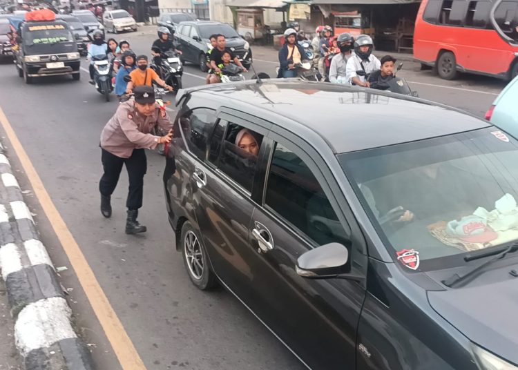 Petugas kepolisian saat membantu kendaraan pemudik yang mogok akibat pecah ban di Jalur Pantura, Kecamatan Palimanan, Kabupaten Cirebon, Senin (15/4/2024).