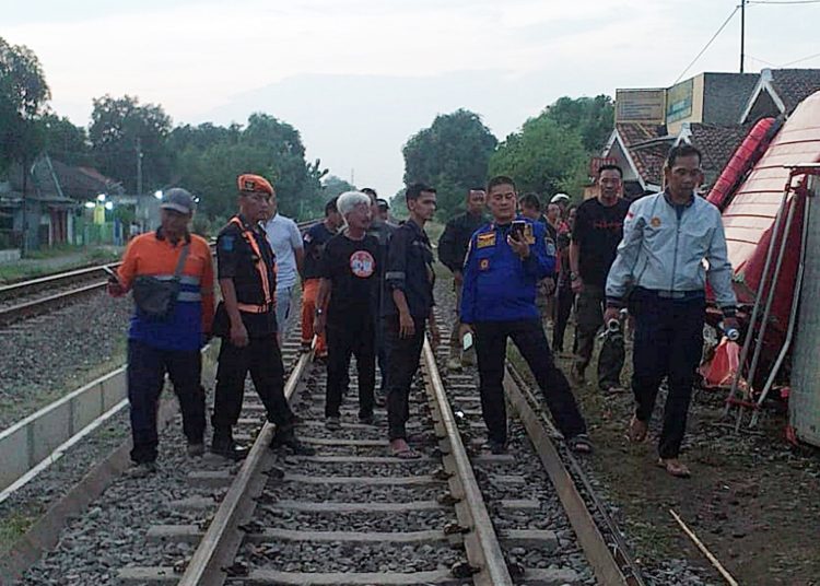 Sebuah mobil Pemadam Kebakaran (Damkar) tertemper lokomotif KA 2526 (Limas dan Cargo) Relasi Kampung Bandan-Kalimas di JPL 93 (JPL dijaga) km 138+2/3 jalur hulu emplasemen Stasiun Haurgeulis Indramayu, Selasa (2/7/2024).*