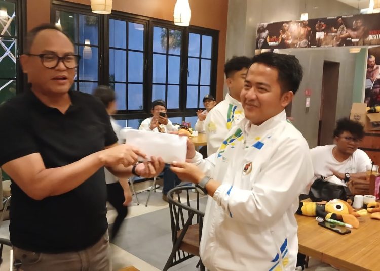 Ketua PWI Jawa Barat, Hilman Hidayat, saat menyerahkan bonus kepada para atlet berprestasi di Powarnas Banjarmasin, Kalimantan Selatan, Sabtu (24/8/ 2024) malam.