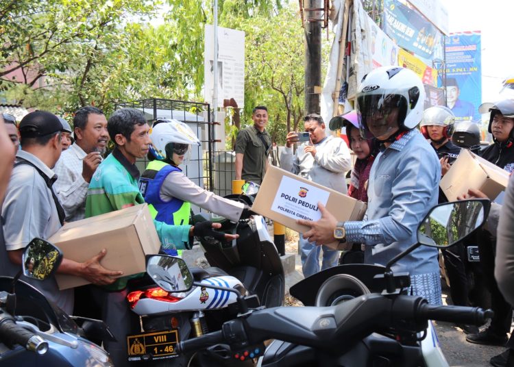 Pj Bupati Cirebon, Wahyu Mijaya (kanan) bersama Kapolresta Cirebon, Kombes Sumarni, saat membagikan paket sembako kepada warga sambil sosialisasi  keselamatan lalulintas, Jumat (18/10/2024)./* (humas Polresta)