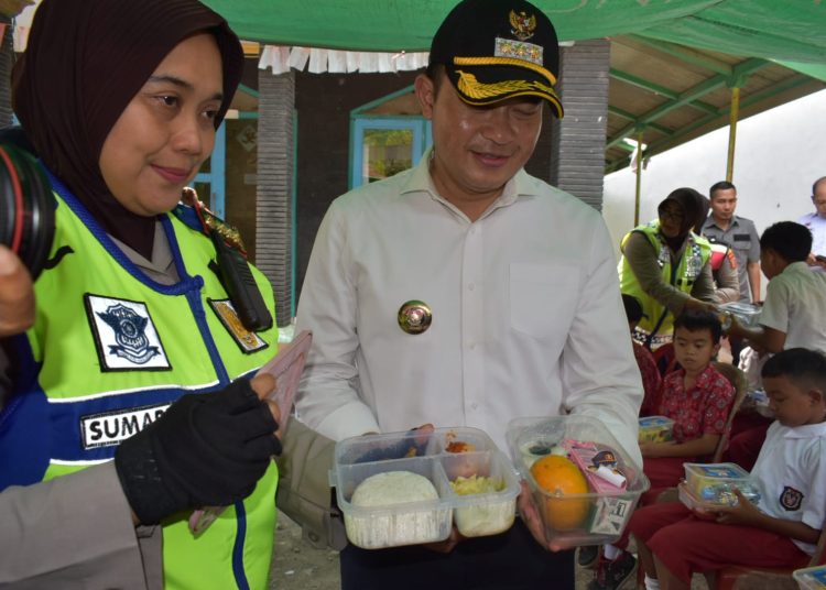 Pj Bupati Cirebon, Wahyu Mijaya dan Kapolresta Cirebon Kombes Sumarni saat membagikan paket makanan bagi pelajar di SD Negeri 3 Cipanas, Kecamatan Dukupuntang, Kabupaten Cirebon, Rabu (23/10/2024)./* (foto: Prokompim)