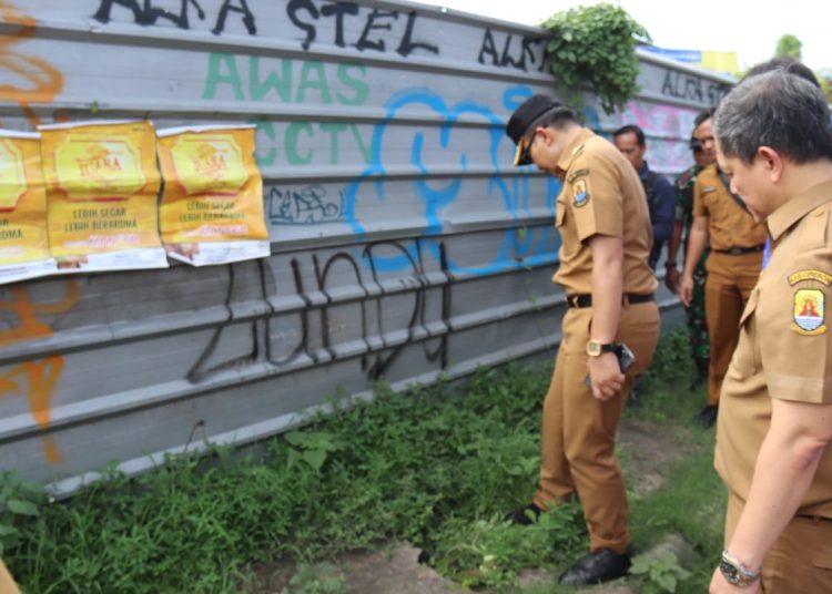 Pj Bupati Cirebon, Wahyu Mijaya didampingi jajaran saat mengecek kondisi saluran air dan kabel listrik di Kecamatan Kedawung, Kabupaten Cirebon, Senin (30/12/2024)./* (foto: Prokompim) 