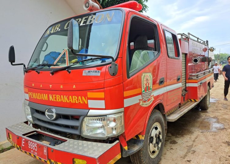 Kendaraan pemadam kebakaran milik Dinas Damkarnat Kabupaten Cirebon saat beroperasi membantu korban banjir di wilayah kerjanya./* (foto: M. Rahmat)