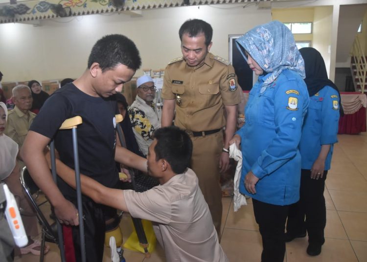 Wakil Bupati Cirebon, Agus Kurniawan Budiman, secara simbolis menyalurkan bantuan dan dorong kesetaraan kerja bagi penyandang disabilitas, di Gedung PGRI, Selasa (25/2/2024)./* (foto: Prokompim) 