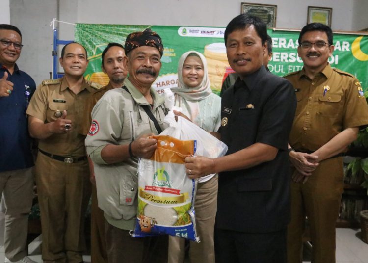 Wali Kota Cirebon Effendi Edo menyerahkan sembako kepada warga dalam Oprasi Pasar Subsidi yang digelar Provinsi Jawa Barat, Selasa (17/3/2025).*